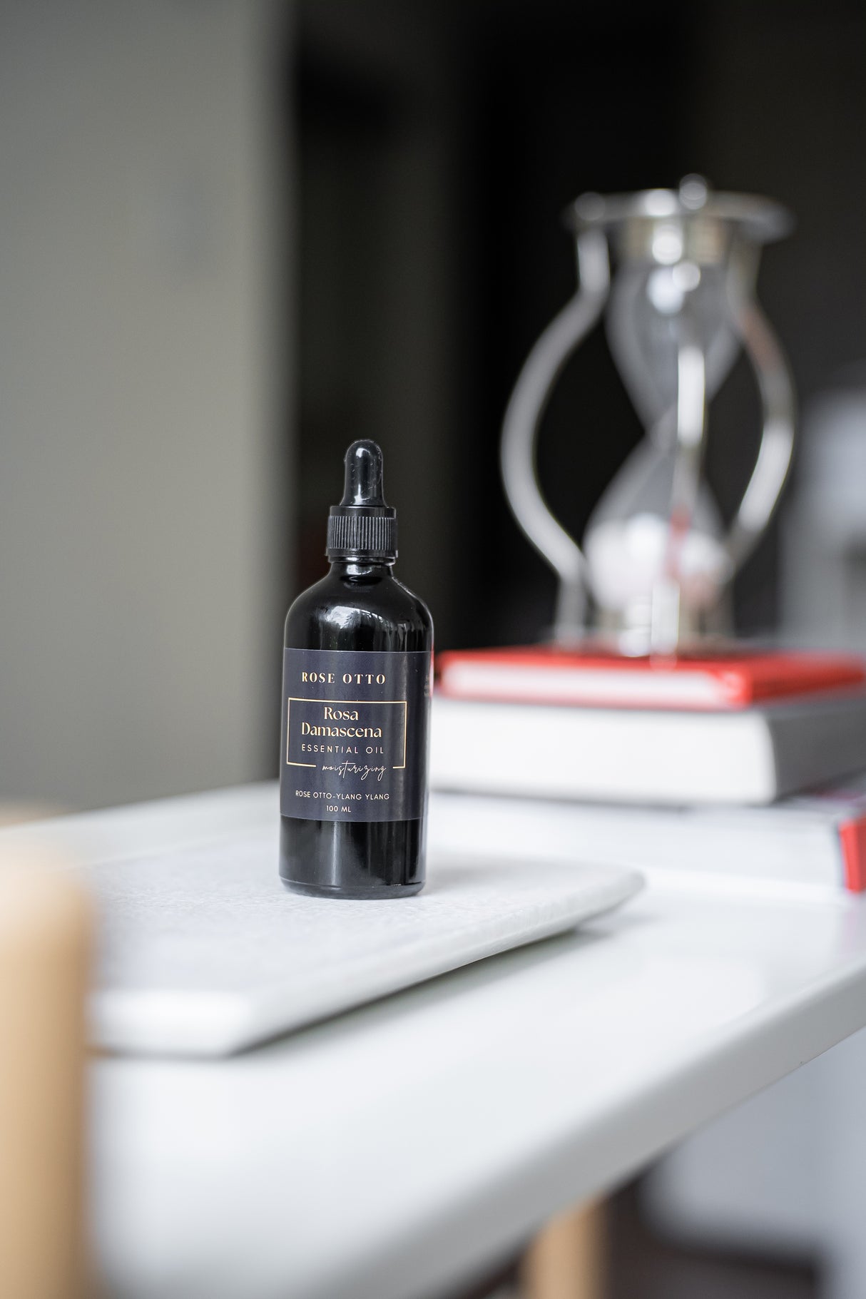 Black dropper bottle on a white surface with a blurred background