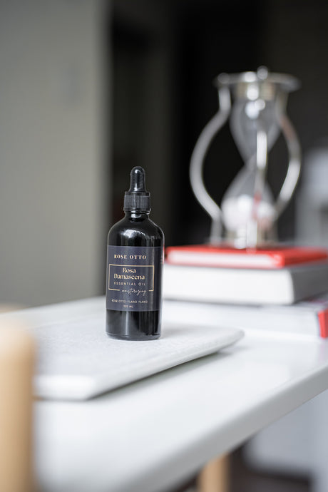 Black dropper bottle on a white surface with a blurred background