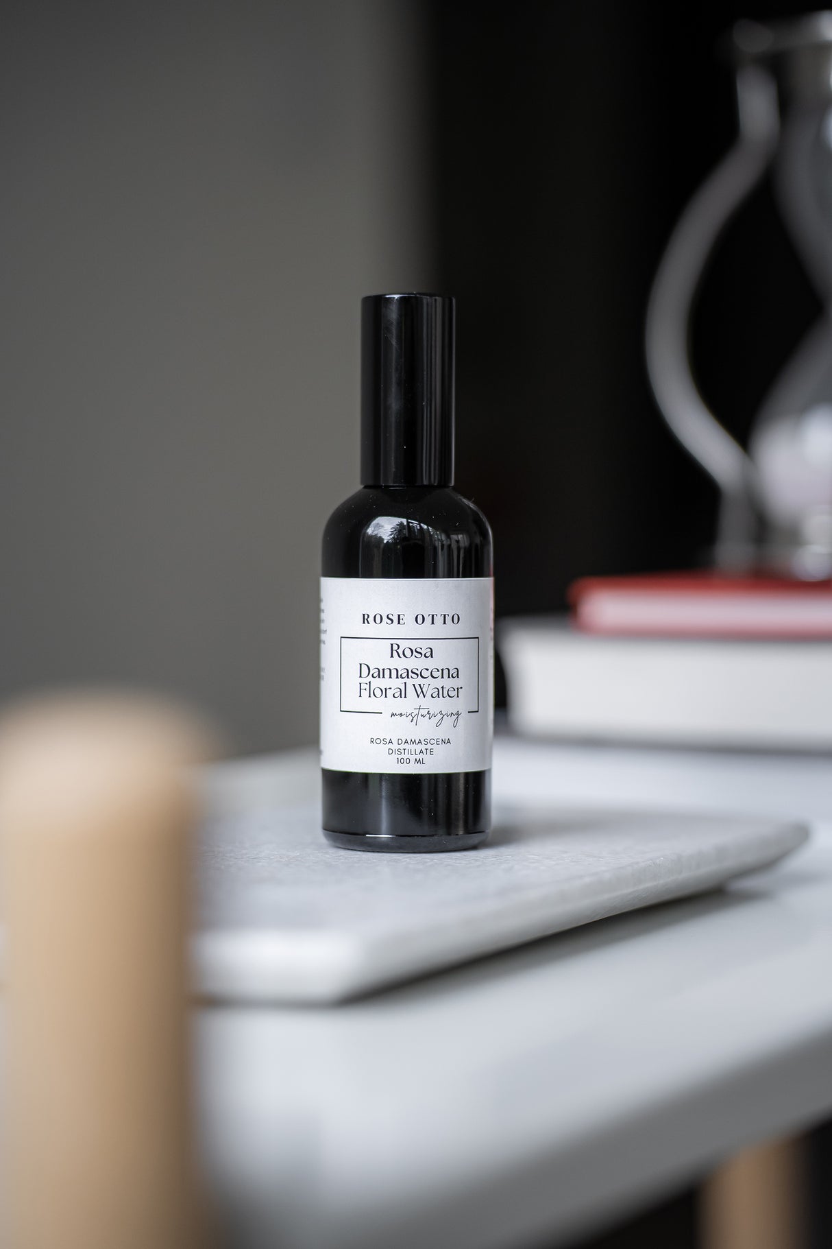 Black bottle with a white label on a marble surface